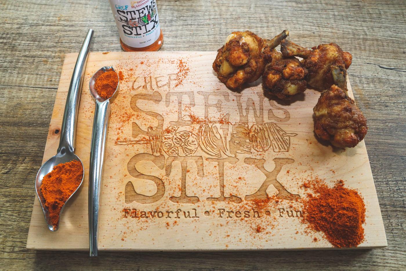 Chef Stew's Signature Seasoning Blend with Chicken Lollipops on branded cutting board
